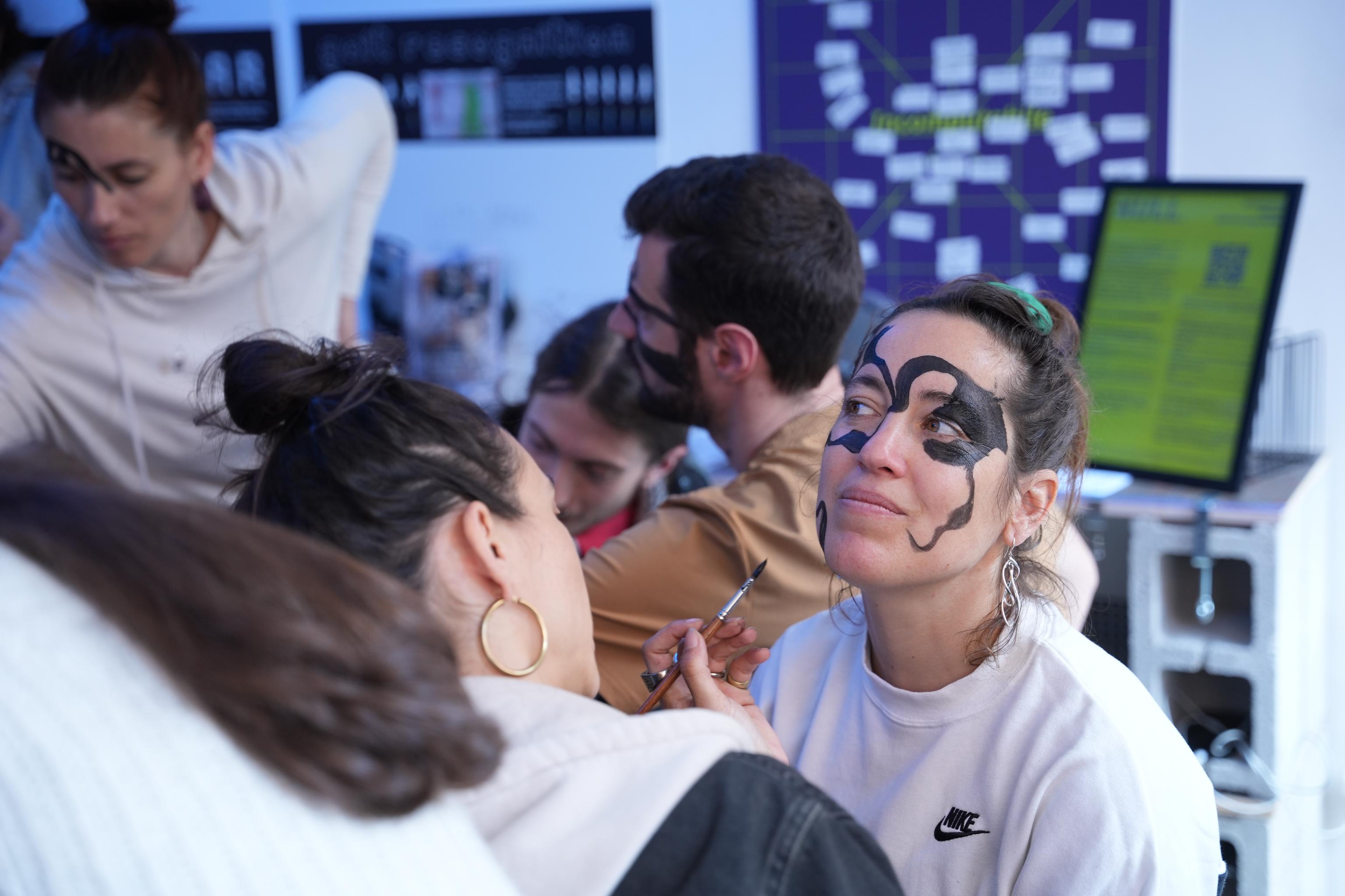 Two participants painting each other's faces